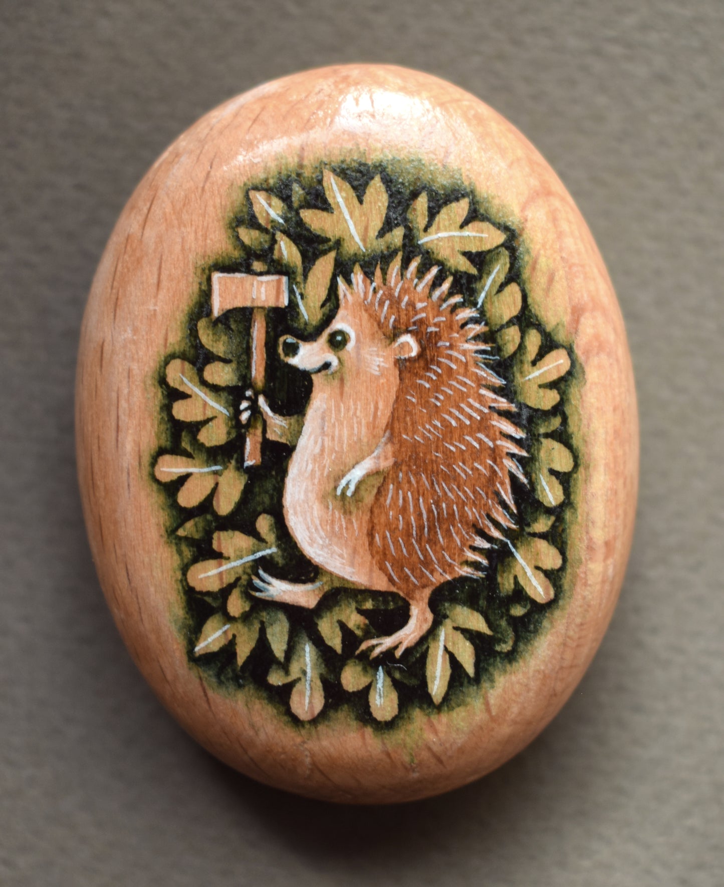 MINI Pebble - Hedgehog with Axe. Watercolour painting on Beech wood