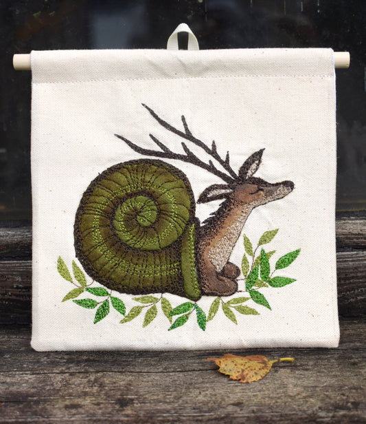 Handmade embroidered deer snail wall hanging on a wooden dowel